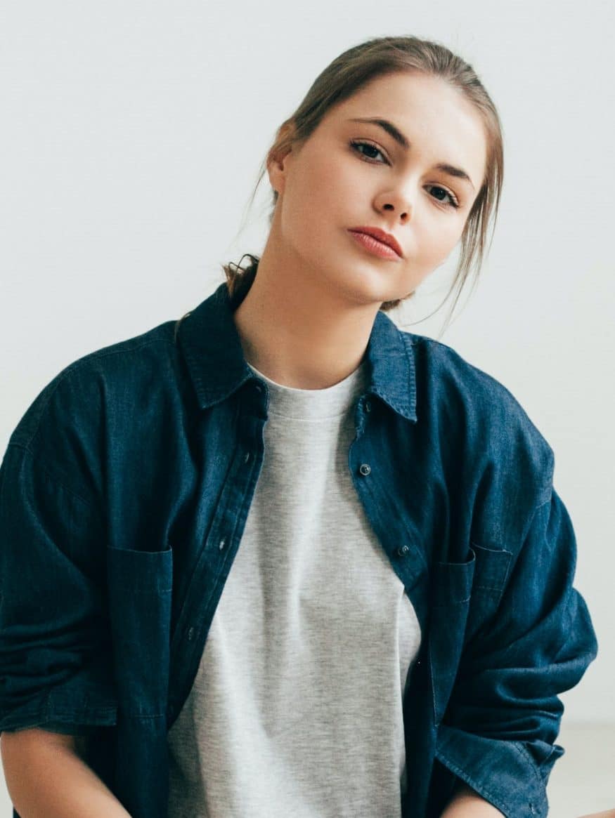 woman in jeans t shirt with long hair posing on the flor e1620267784172