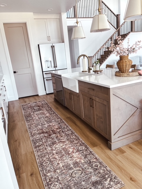 Modern kitchen with light wood cabinetry and a large island with a white countertop.
